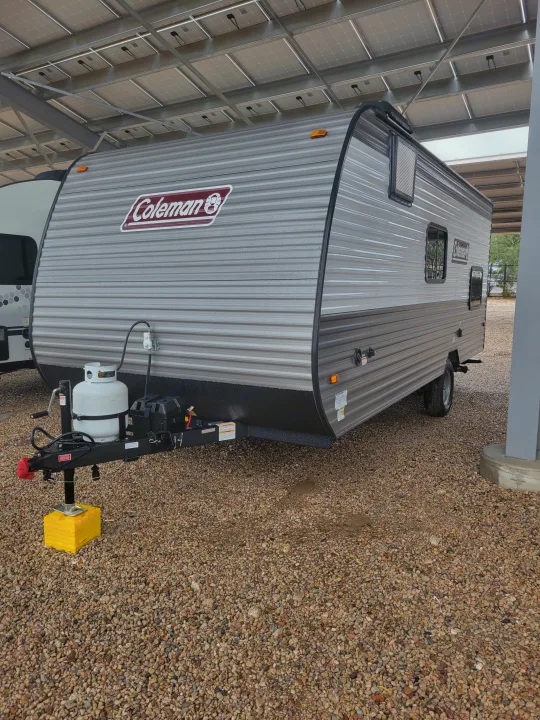 Coleman RV travel trailer rental parked under solar panels on gravel.. Coleman Coleman Lantern 17B 2024