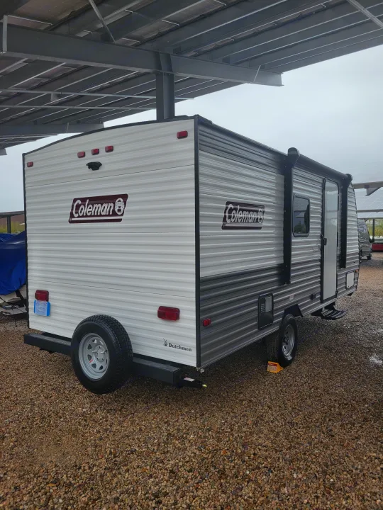 Coleman travel trailer for rv rental, parked on gravel. Perfect for camping adventures under a solar carport.. Coleman Coleman Lantern 17B 2024