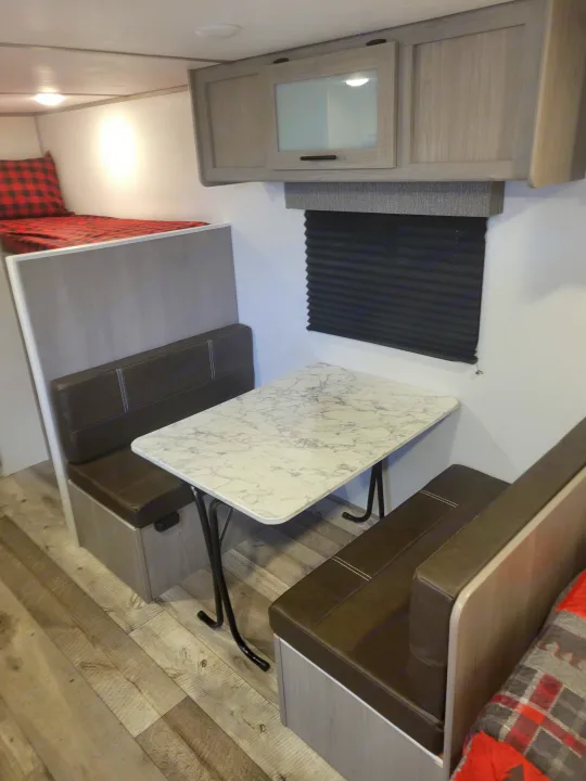 This RV rental offers a cozy dinette with a marble-look table and benches, plus a practical bunk bed and storage.. Coleman Coleman Lantern 17B 2024