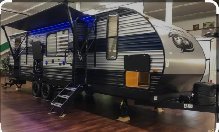 Large silver & black Cherokee travel trailer RV with blue LED awning. Explore this spacious RV for your next rental adventure.. Forest River Cherokee 2022