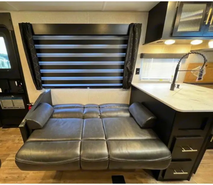 RV rental: Inside, a comfy convertible sofa/bed, kitchen island with faucet, and modern window blinds for privacy.. Forest River Cherokee 2022