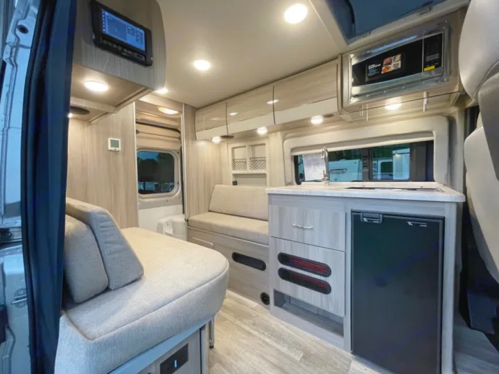 This rv rental interior features a compact kitchen with fridge/sink, cozy seating, and modern cabinetry, perfect for road trips.. Thor Scope 18G 2024