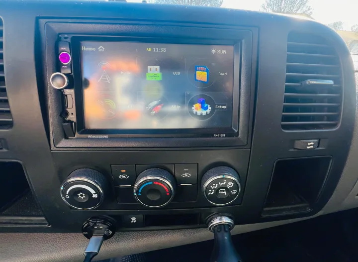Inside an RV rental: Dashboard with Reakosound touchscreen stereo (AM 11:38, Radio, USB) & climate controls, ready for travel.. Chevrolet Silverado 1500 2009