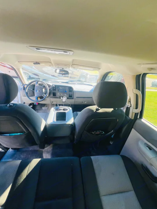 Inside an RV rental vehicle or tow truck, showing front interior, steering wheel, and other RVs outside.. Chevrolet Silverado 1500 2009
