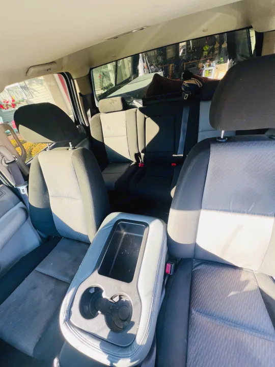Clean & spacious RV rental interior: rear seats, center console with cup holders, illuminated by sunlight.. Chevrolet Silverado 1500 2009