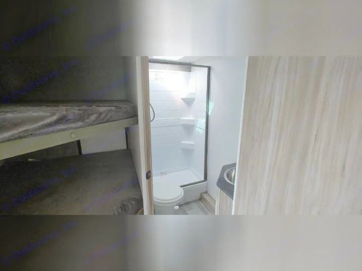 Cozy RV rental interior featuring bunk beds and a compact bathroom with shower and toilet, perfect for family travel.. Winnebago 2301BHS 2022