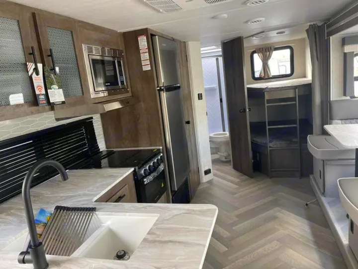 Modern RV rental interior with full kitchen, bunk beds, dining, and bathroom. Great for trips!. Forest River Salem Cruise Lite 2021