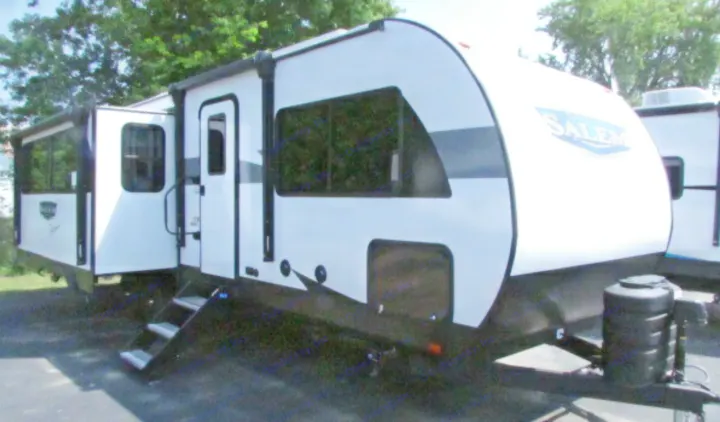 A white and black travel trailer RV with an extended slide-out and steps, ideal for an rv rental adventure.. SALEM 27REX 2024