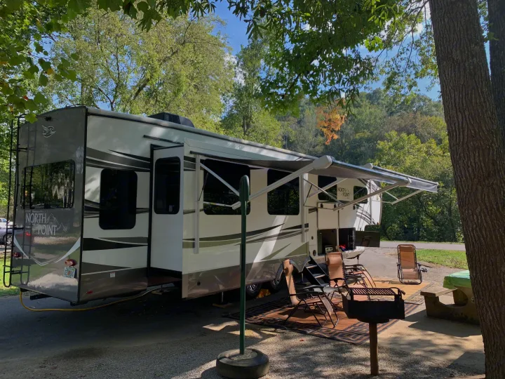This spacious RV rental offers a comfortable campsite experience with its extended awning, outdoor living area, and grill.. Jayco North Point 2021