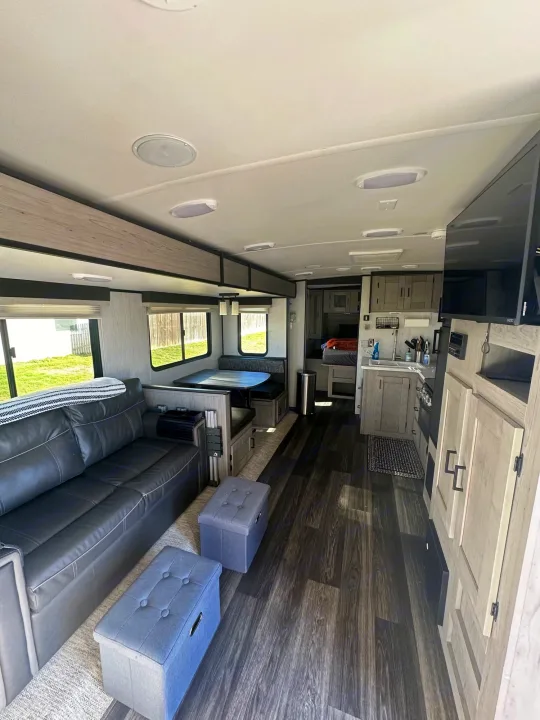 Spacious and modern rv rental interior featuring a lounge sofa, dinette, kitchen, and bedroom area.. Heartland RVs Mallard 2021