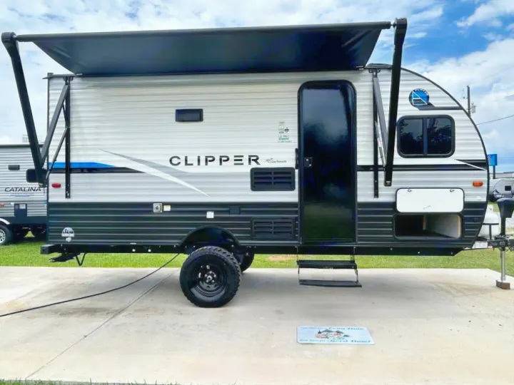 This modern Clipper travel trailer, featuring an awning and large tires, is perfect for your next RV rental adventure.. Coachmen Clipper 2024