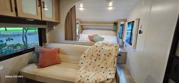 Experience comfort! RV rental interior showing a cozy living area with a couch and a separated bedroom.. Forest River Wildwood X-Lite Platinum 2024