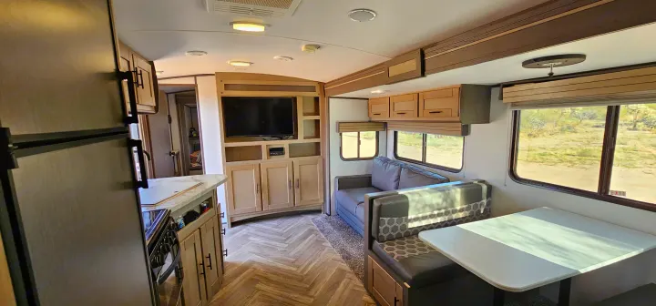 Spacious and modern rv rental interior showcasing a bright kitchen, cozy living area, and a functional dinette. Ideal for travel.. Cruiser RV Shadow Cruiser 2021