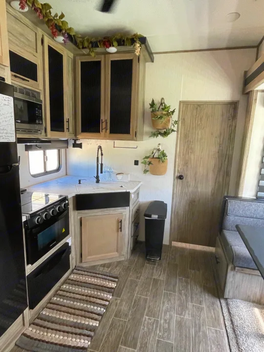 Spacious RV rental interior featuring a full kitchen, dinette, and cozy decor, perfect for travel adventures.. Forest River Cherokee Arctic Wolf 2021