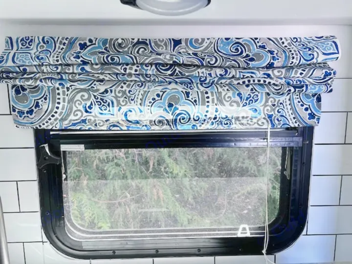 Stylish blue & gray patterned Roman shade enhances this RV rental's window. Offers privacy/light control in a cozy interior.. Winnie Drop Winnie Drop Trailer 2017
