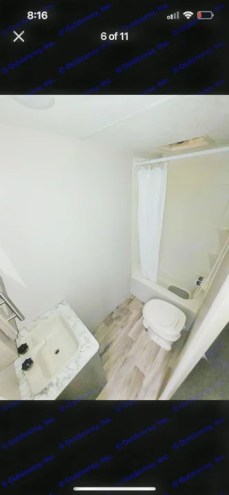 Compact RV rental bathroom with sink, toilet, and shower/tub combo, featuring wood-look flooring.. KZ Escape 2019