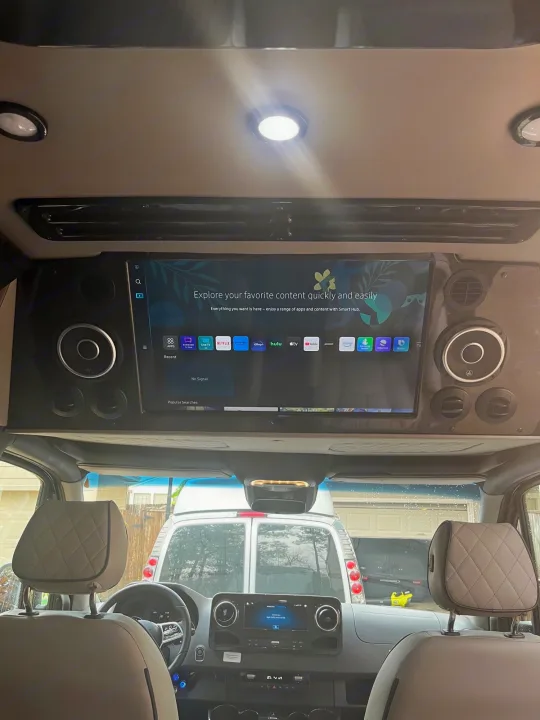 RV rental interior with a large overhead smart TV showing Samsung Smart Hub, perfect for entertainment on road trips.. Midwest Automotive Designs Day Cruiser 2024