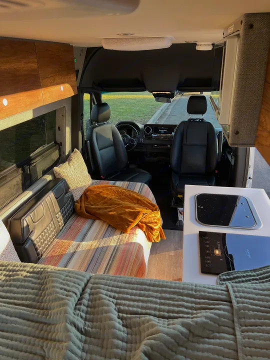 This RV rental interior features a bed, kitchen counter with cooktop, and driver's cabin, ready for adventures.. Storyteller Overland Storyteller Overland Class B 2020