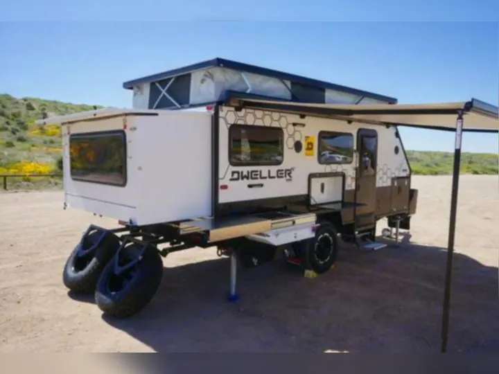 This robust pop-top camper, ideal for RV rental, is equipped with an awning and rear spare tires, ready for adventure.. OBI OBI Popup Trailer 2022