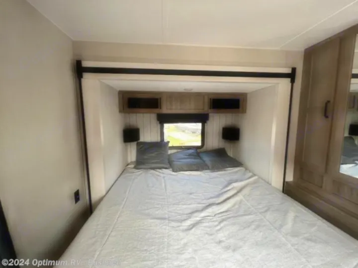 RV rental bedroom with a comfy queen bed, overhead cabinets, a window, and a mirrored wardrobe. Ready for your trip!. Forest River Palomino Puma 2022