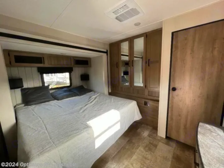 RV rental bedroom features a large bed, overhead cabinets, and a mirrored wardrobe, maximizing comfort and storage.. Forest River Palomino Puma 2022