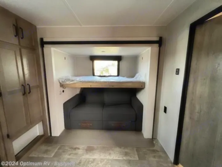 RV rental: Inside a versatile RV bunk area featuring a sofa, upper bed, and storage cabinets. Great for family trips.. Forest River Palomino Puma 2022
