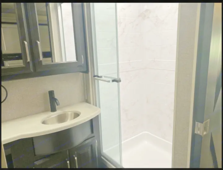 Modern RV rental bathroom features a compact vanity with sink and faucet, plus a clean glass-enclosed shower.. Jayco Precept 2021