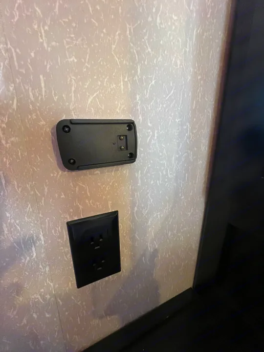 RV rental: Light wall with black electrical outlet and a charging/device mount above, common in modern RV interiors.. Forest River Cherokee 2022