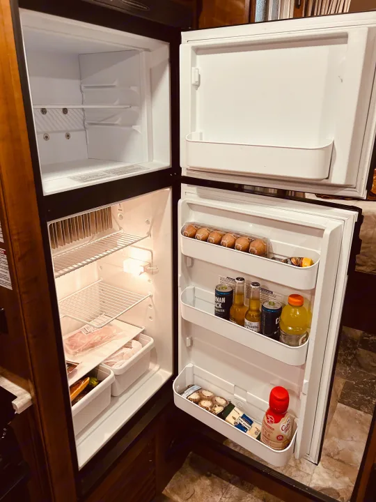 RV rental fridge open, stocked with eggs, drinks, meat, and cheese. Freezer empty. Ready for your next adventure!. COACHMEN LEPRECHAUN 2019