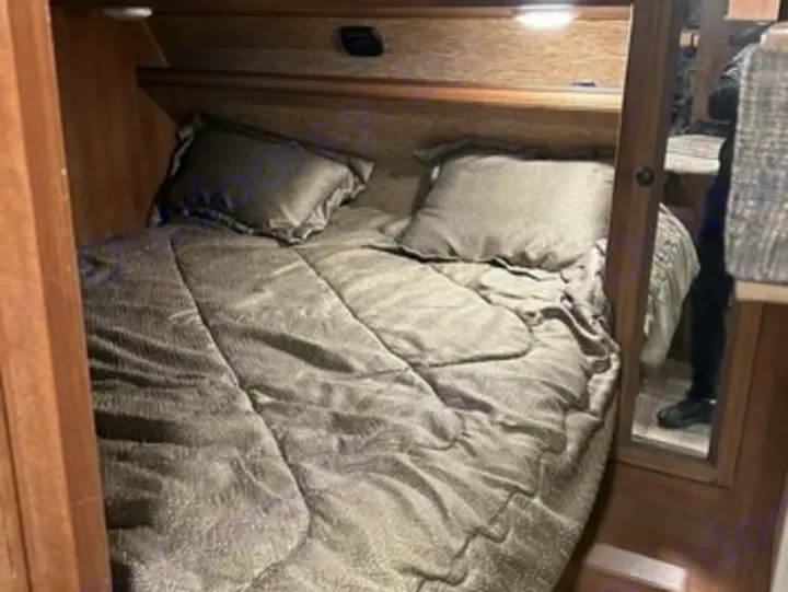 Experience comfort in an RV rental! This image shows a cozy, neatly made bed inside a modern RV interior, ready. Heartland RVs Sundance XLT 2016