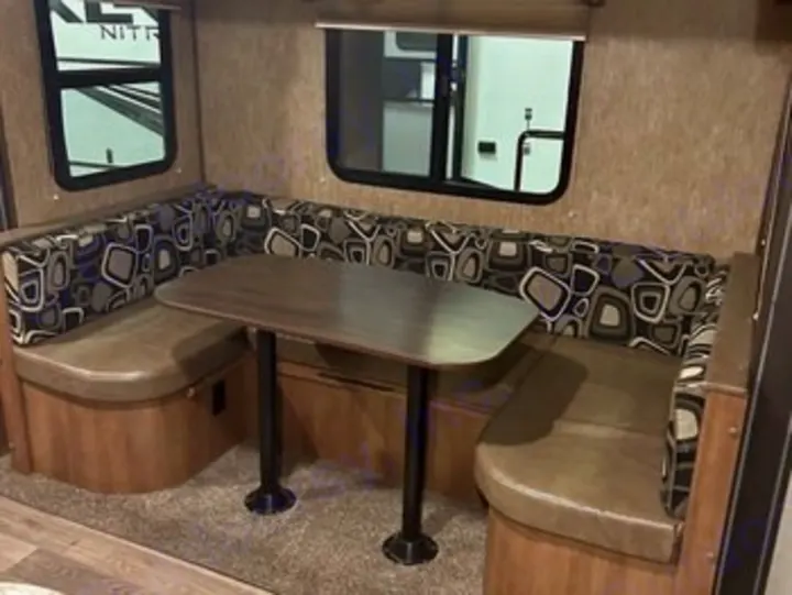 Cozy U-shaped dinette area in an RV rental, featuring a central table and. Heartland RVs Sundance XLT 2016