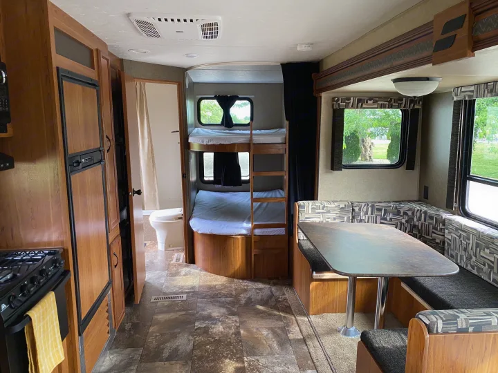 This inviting RV rental interior showcases a full kitchen, bunk beds, a bathroom, and a cozy dinette seating area.. Starcraft Ar-One MAXX 2016
