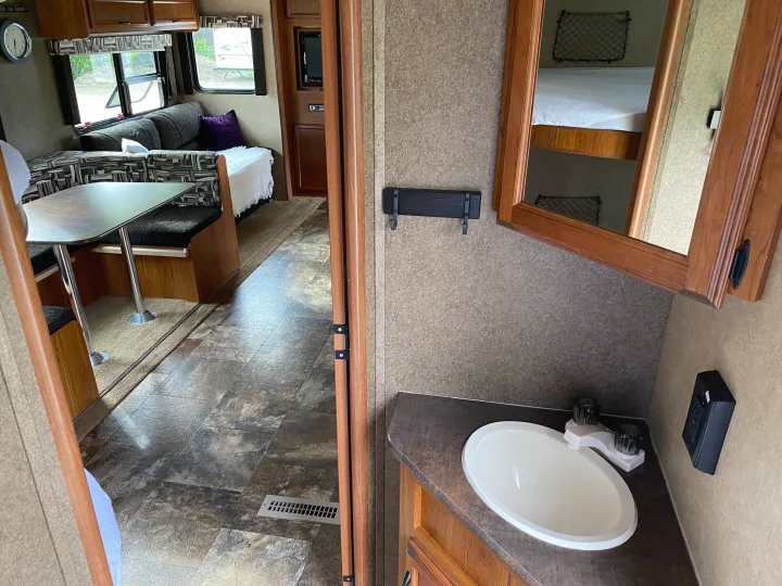 RV rental interior showcasing a dinette, a bathroom vanity with sink, and mirrored bunk beds.. Starcraft Ar-One MAXX 2016
