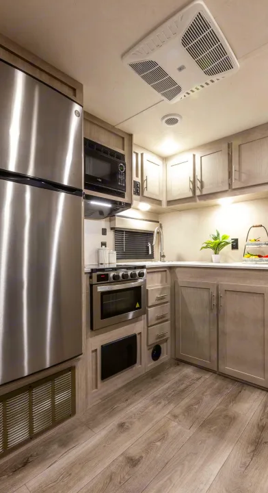 Spacious RV rental kitchen with stainless steel appliances, ample storage, and modern finishes for comfortable travel.. Coachmen Catalina 2022