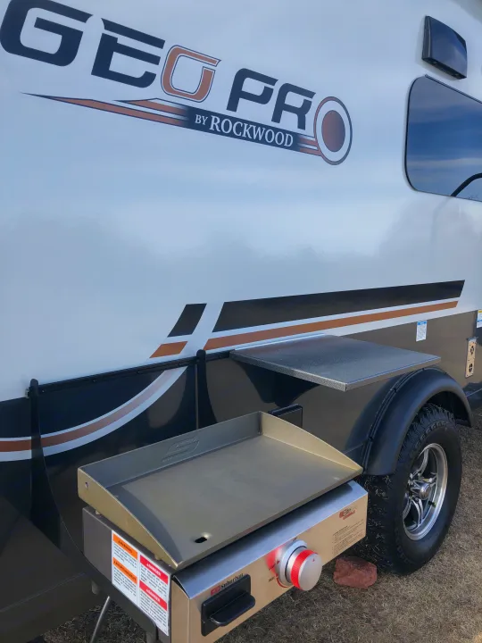 An RV rental: a Geo Pro travel trailer with an attached outdoor Suburban griddle and side table for convenient camp cooking.. Forest River Rockwood Geo Pro 2024