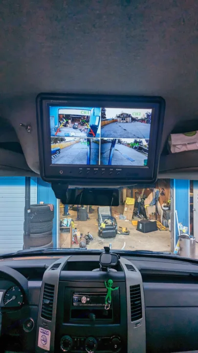 Inside an RV rental, a multi-camera monitor provides exterior views for navigation and safety in a garage setting.. Dodge Sprinter 2007