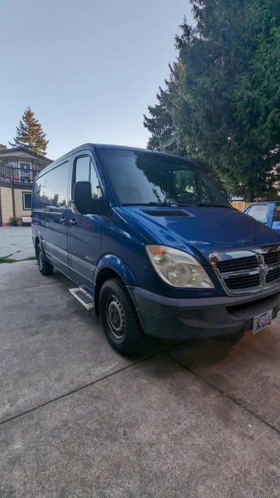 This blue Dodge Sprinter 2500 van with side steps, ideal for an RV rental adventure, is ready for camping trips.. Dodge Sprinter 2007