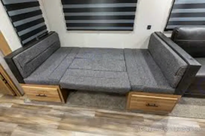 RV rental: Grey upholstered RV dinette bench converted to a bed with storage drawers. Ideal for travel/camping.. Forest River Cherokee Arctic Wolf 2021