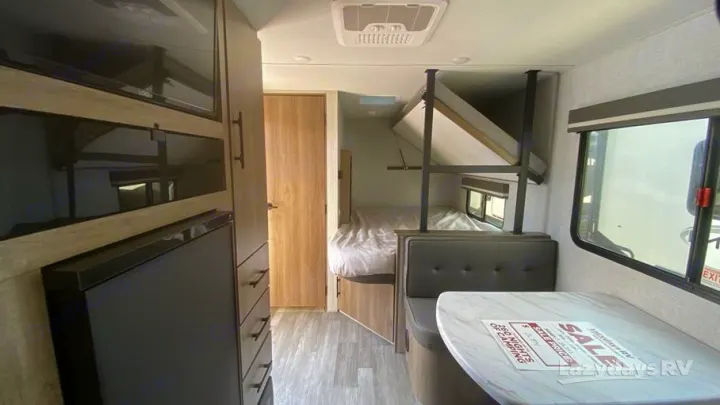 Inside an RV rental: a compact interior with a dinette, kitchen, bunk beds, and a main bed, ready for your next adventure.. Grand Design 2023