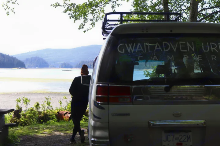 Scenic RV rental: a person watches a serene bay and mountains from their GWAI! Adventure camper.. nissan elgrand 1997