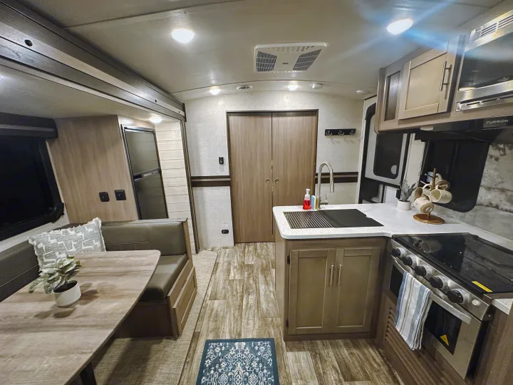 Clean and inviting RV rental interior, showing a fully equipped kitchen, dining table, and cozy seating. Ready for adventures.. Crossroads RV Sunset Trail Super Lite 2022