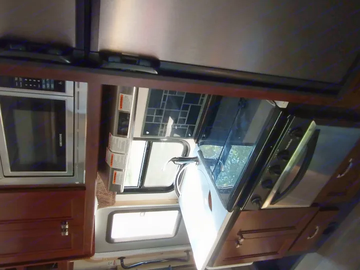 Explore your RV rental's kitchen! Features a microwave, stovetop/oven, sink, and ample cabinet storage.. Forest River Forester 2018