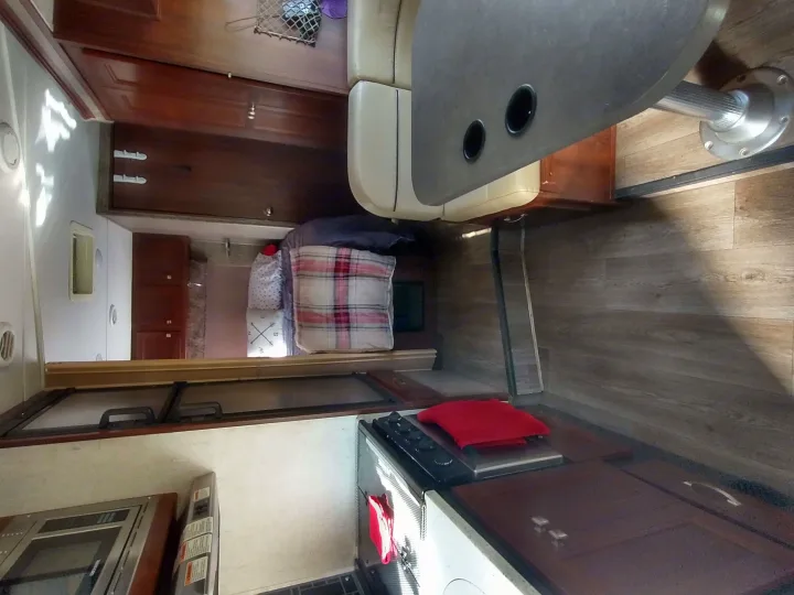 RV rental: Living space with dining booth, kitchen area, bed, and wood floors. Comfortable travel home.. Forest River Forester 2018