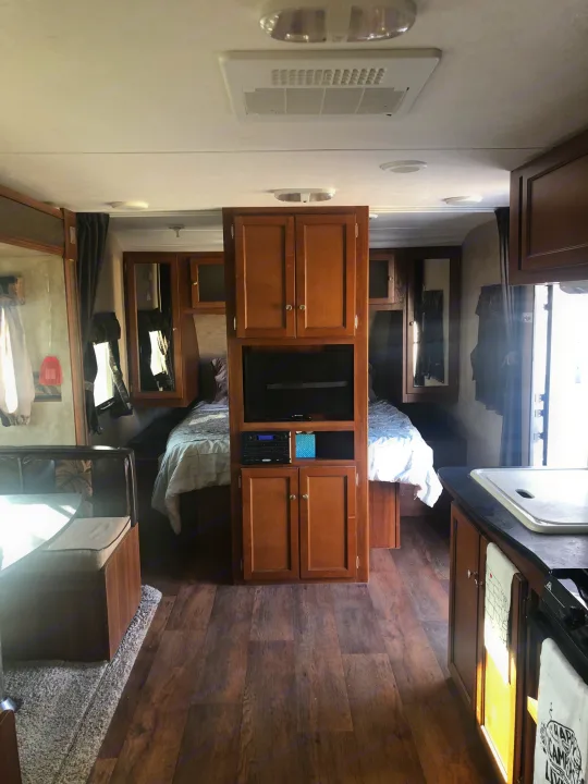 Experience comfort in this RV rental's cozy interior, featuring a bedroom, dinette, and well-equipped kitchen.. Keystone RV Bullet Ultra Lite 2015