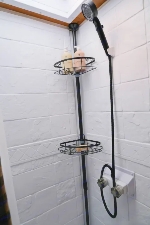 Experience comfort in this RV rental's shower, featuring white textured walls, a black shower caddy with toiletries, and a functional shower head.. Sunray Sunlite 16BH 2023