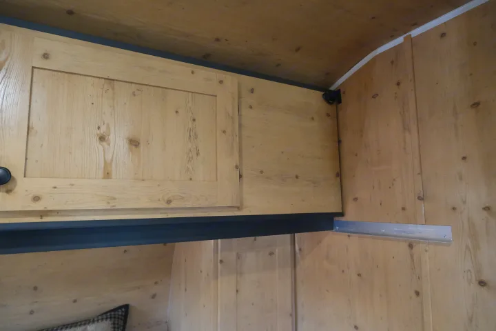 Inside an rv rental, light wood overhead cabinets and paneling, with a black support beam and metal track for added storage.. Sunray Sunlite 16BH 2023