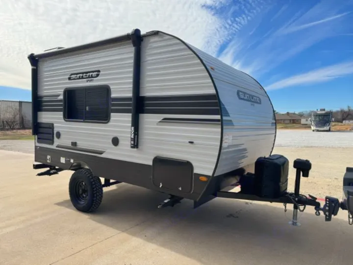 This compact grey Sun Lite Sport travel trailer with rugged tires is available for RV rental, perfect for outdoor camping adventures.. Sunray Sunlite 16BH 2023