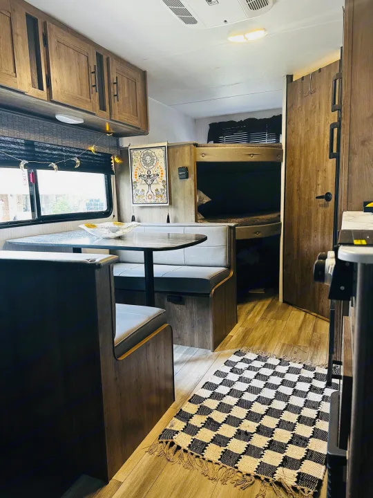 Cozy RV rental interior featuring a dinette, overhead cabinets, and bunk beds. Perfect for your next road trip adventure.. Heartland RVs Pioneer 2024