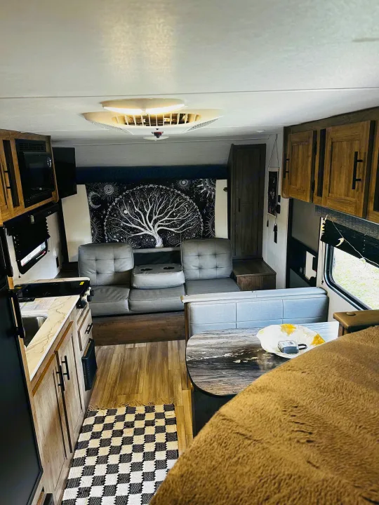 Inside a cozy RV rental: a modern living space with kitchen, dinette, and comfy seating. Ideal for travel adventures.. Heartland RVs Pioneer 2024
