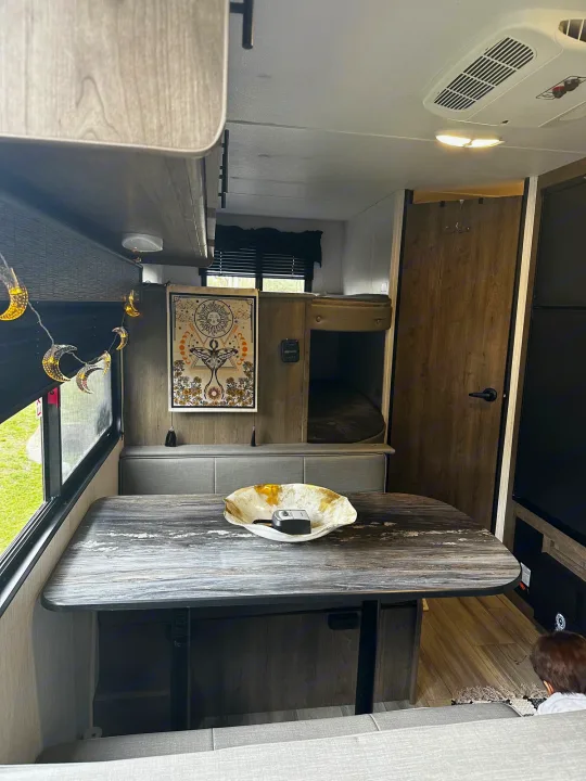 Explore this RV rental's inviting interior: dinette, bunk beds, and celestial decor. Ideal for your next trip.. Heartland RVs Pioneer 2024